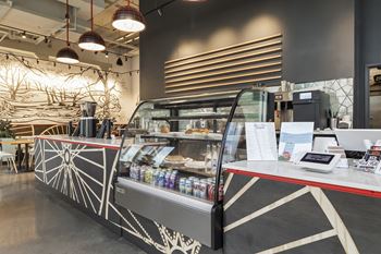 a coffee shop with a black and white mural on the wall and a red counter with a